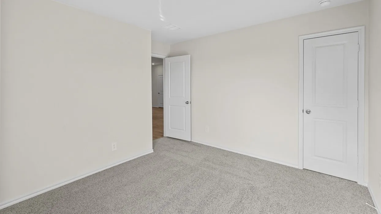 Neutral-toned walls complement plush grey carpeting