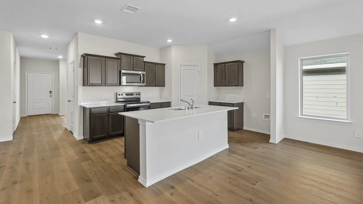 Open-concept kitchen featuring an island with a sink, dark wood-finish cabinetry, stainless steel appliances, white subway tile backsplash, and wood-finish flooring