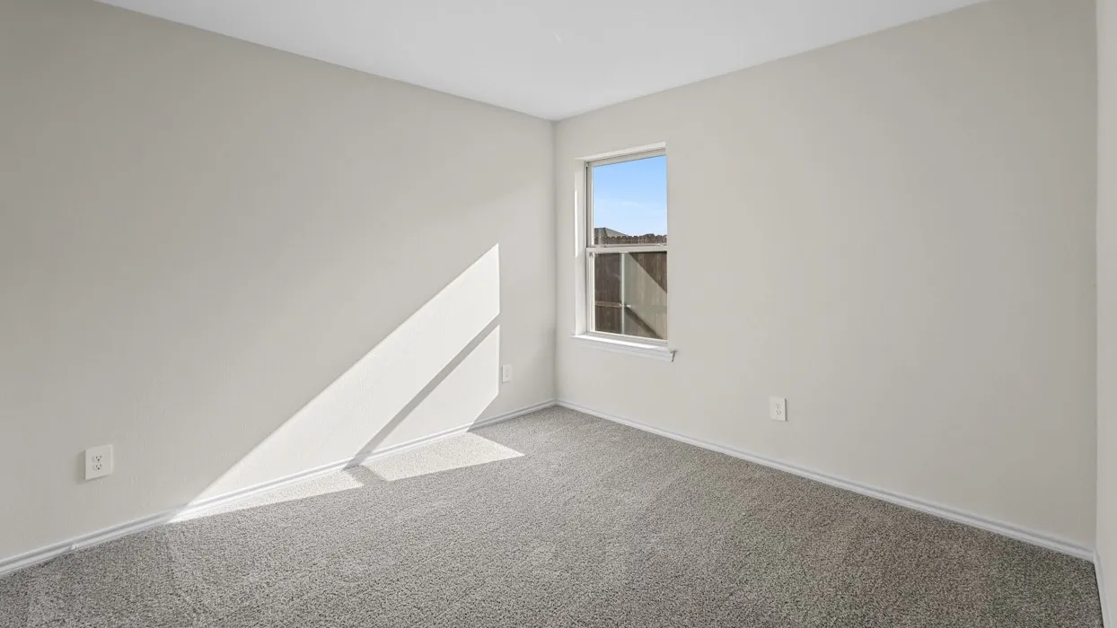 Neutral-toned room featuring a single window, light-colored walls, gray carpeting, and white baseboards