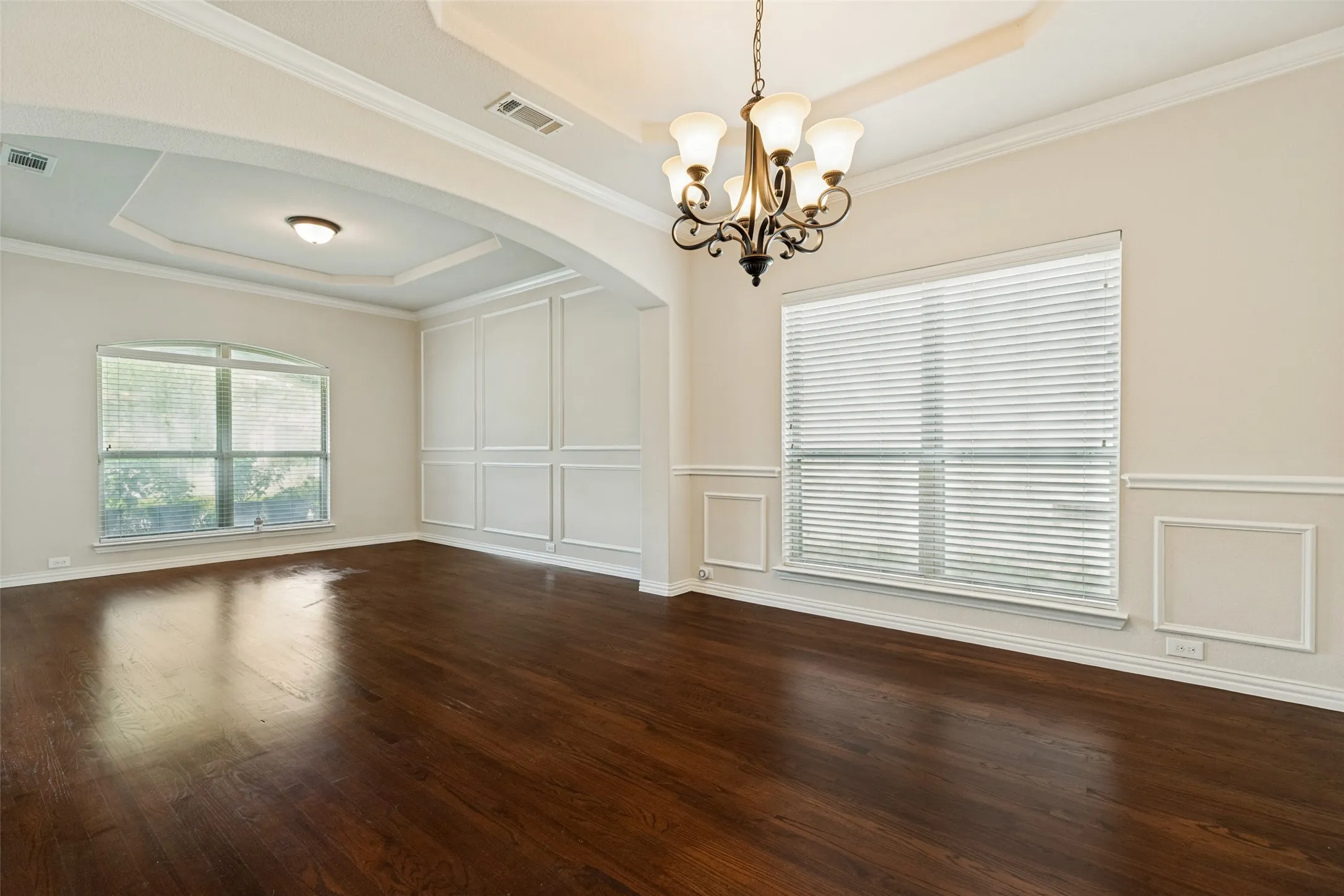 Front Large Dining area featuring wood-finish flooring, two large windows, and a tray ceiling