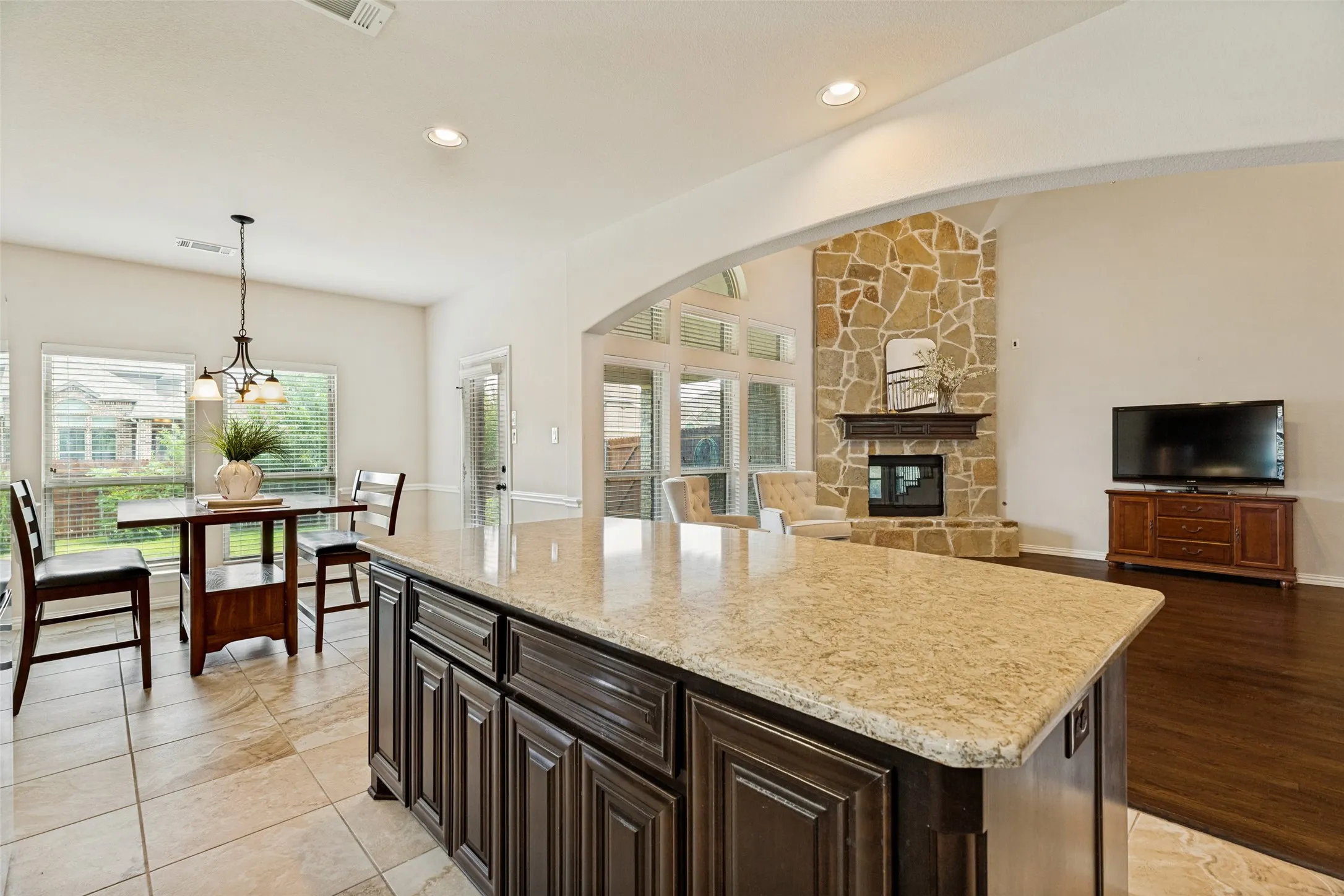 Kitchen island featuring a light-toned granite countertop and dark wood cabinetry