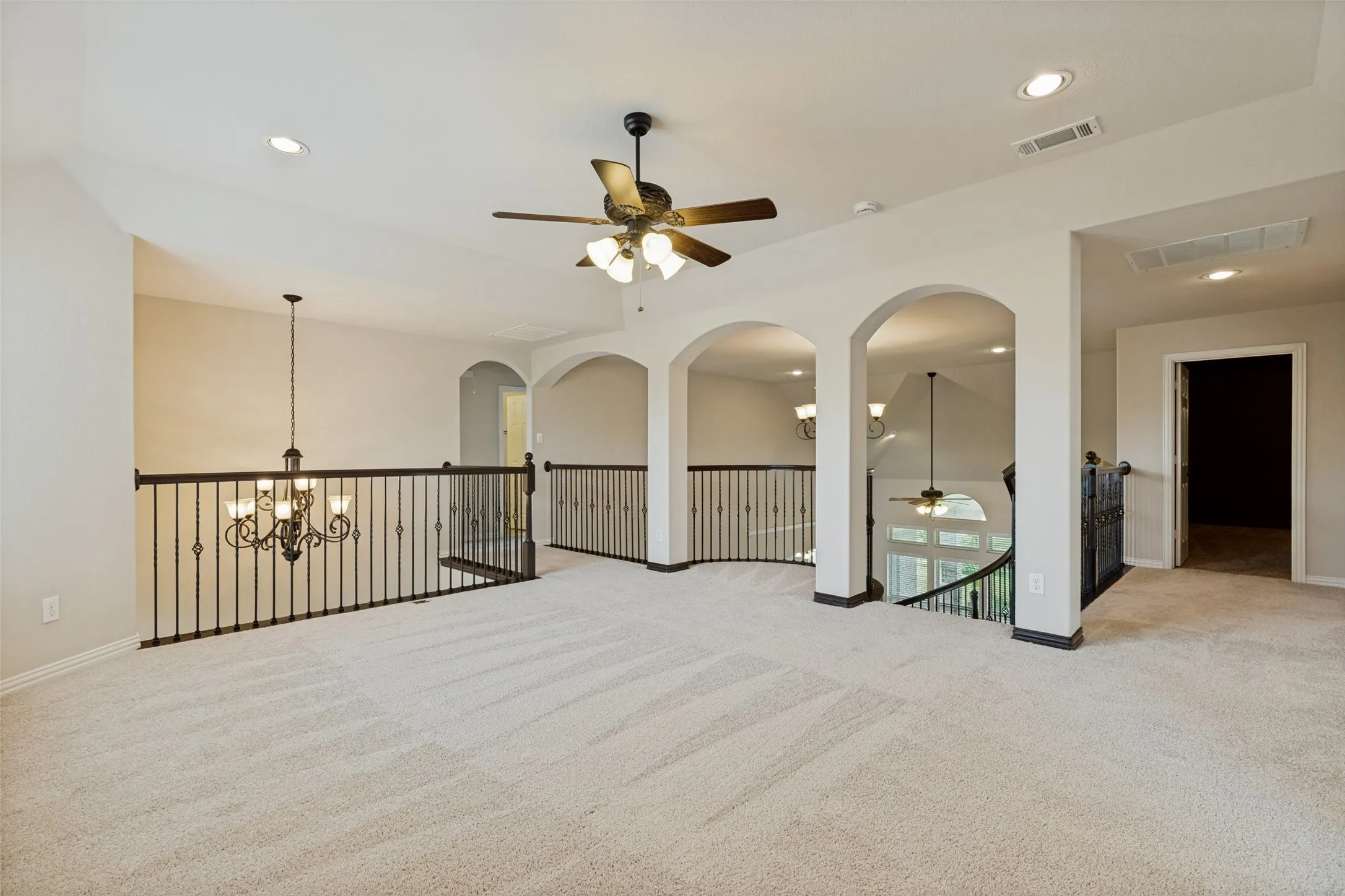 View 1: Spacious carpeted loft area featuring an ornate chandelier, recessed lighting, and a ceiling fan