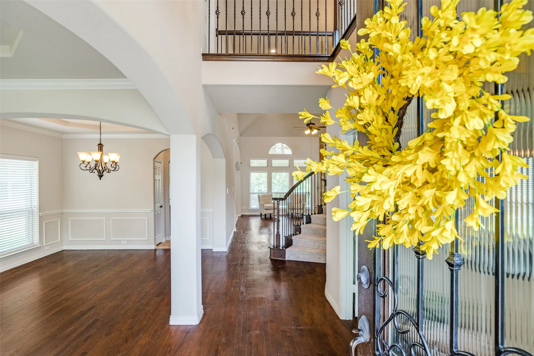 Entry Foyer way featuring wood-finish flooring, a dark wood door with decorative glass and an arched transom, and recessed ceiling details