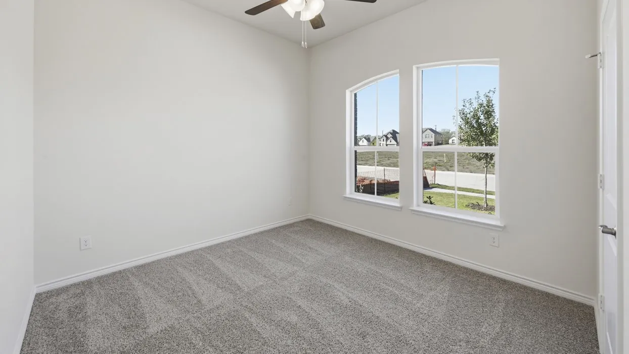 Room featuring light gray carpeting, crisp white walls, and a ceiling fan with integrated lighting
