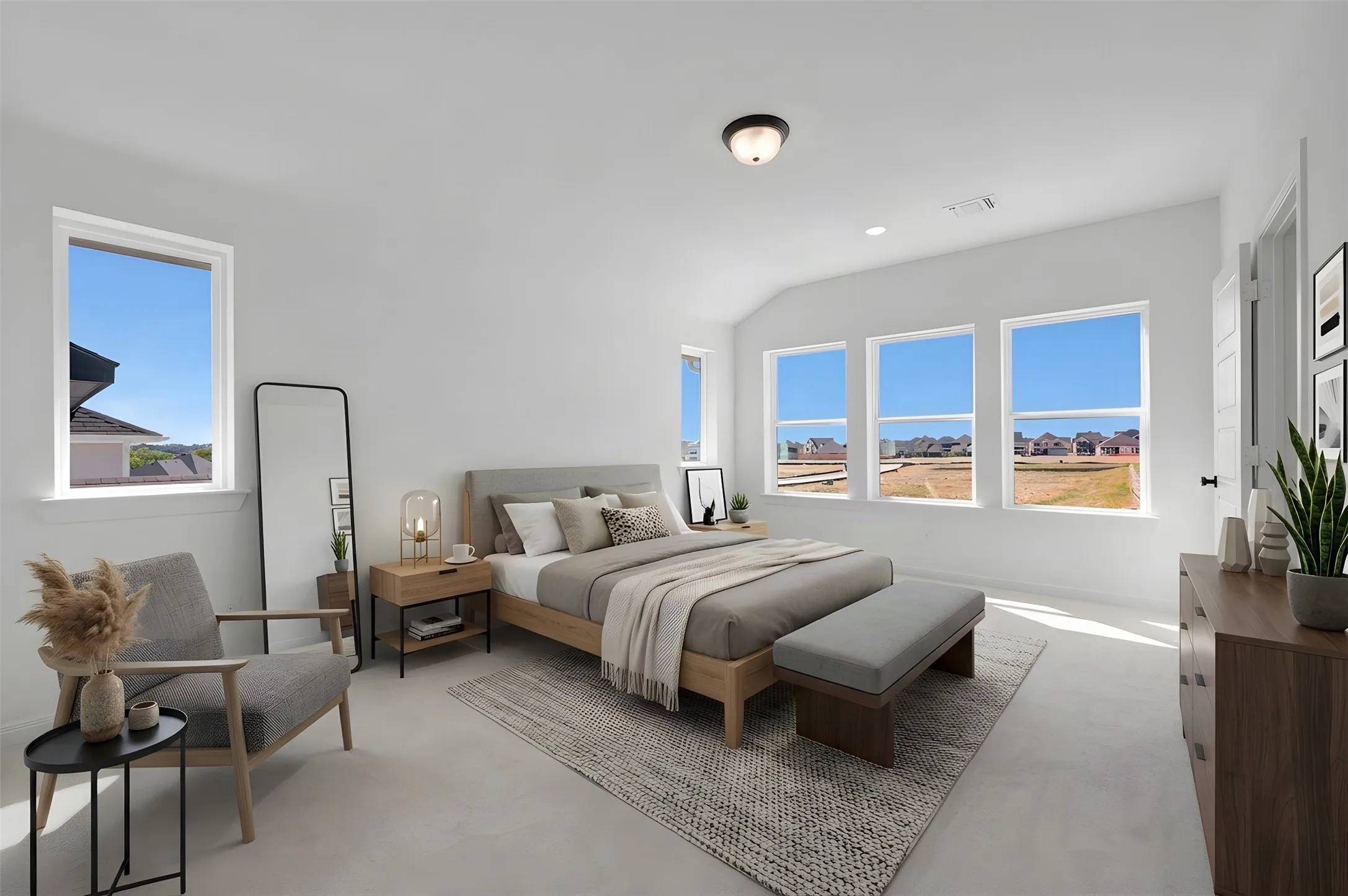 Vaulted ceilings, multiple windows, recessed lighting, and a neutral color palette