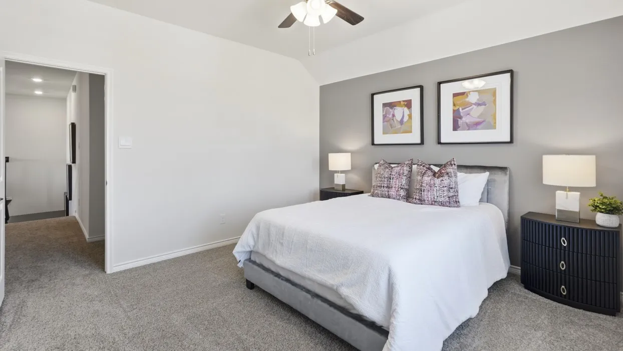 Carpeted room with a ceiling fan, a contrasting accent wall, and recessed lighting visible through the doorway