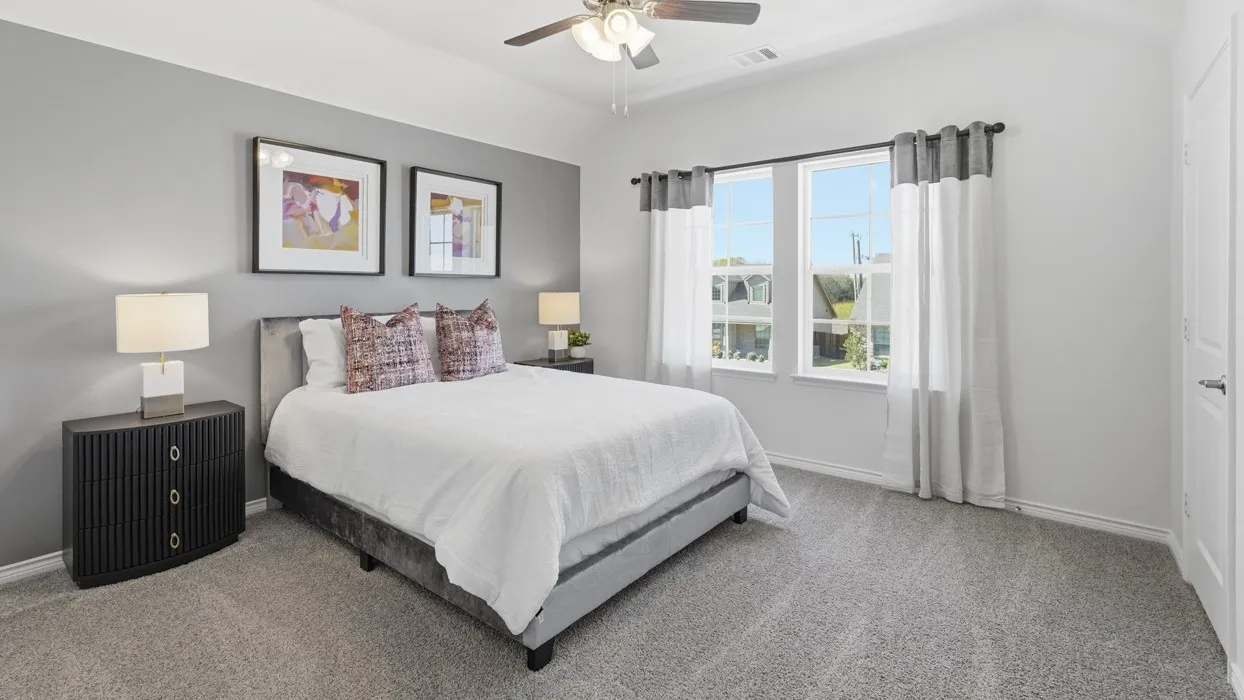 Carpeted room featuring a white ceiling, a ceiling fan with integrated lighting, and a window with white and gray curtains