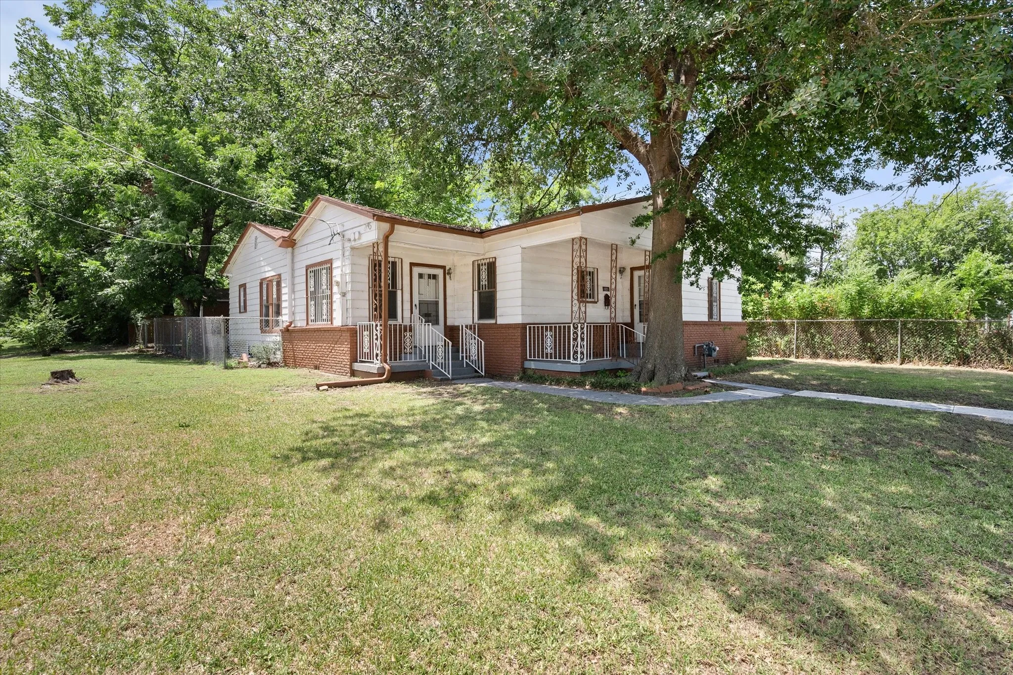 Situated on a 0.13-acre corner lot, this flexible Corsicana property is shaded by mature trees.