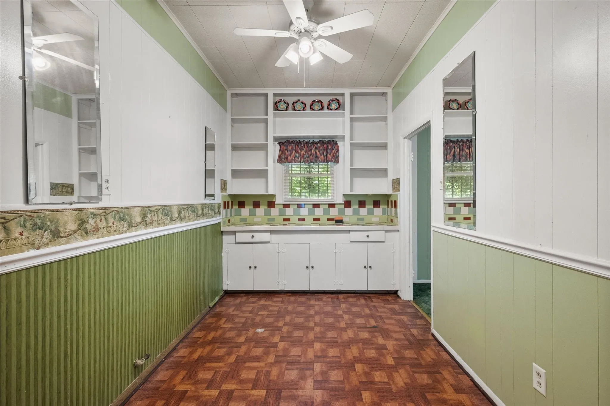 The dining area features built-in cabinetry, open shelving, a ceiling fan, and additional storage or display space.
