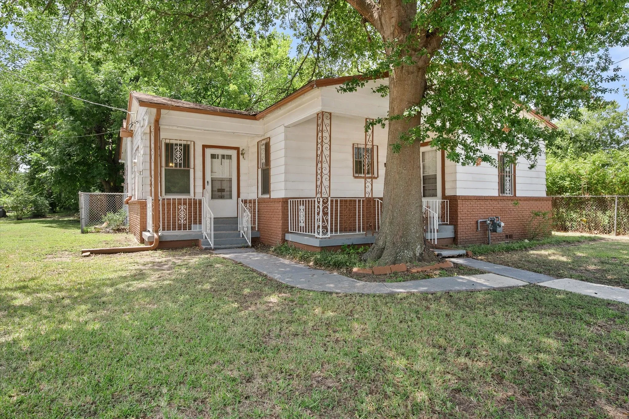 The front walkway connects multiple entrances, reflecting the property’s former duplex configuration and future conversion possibilities.