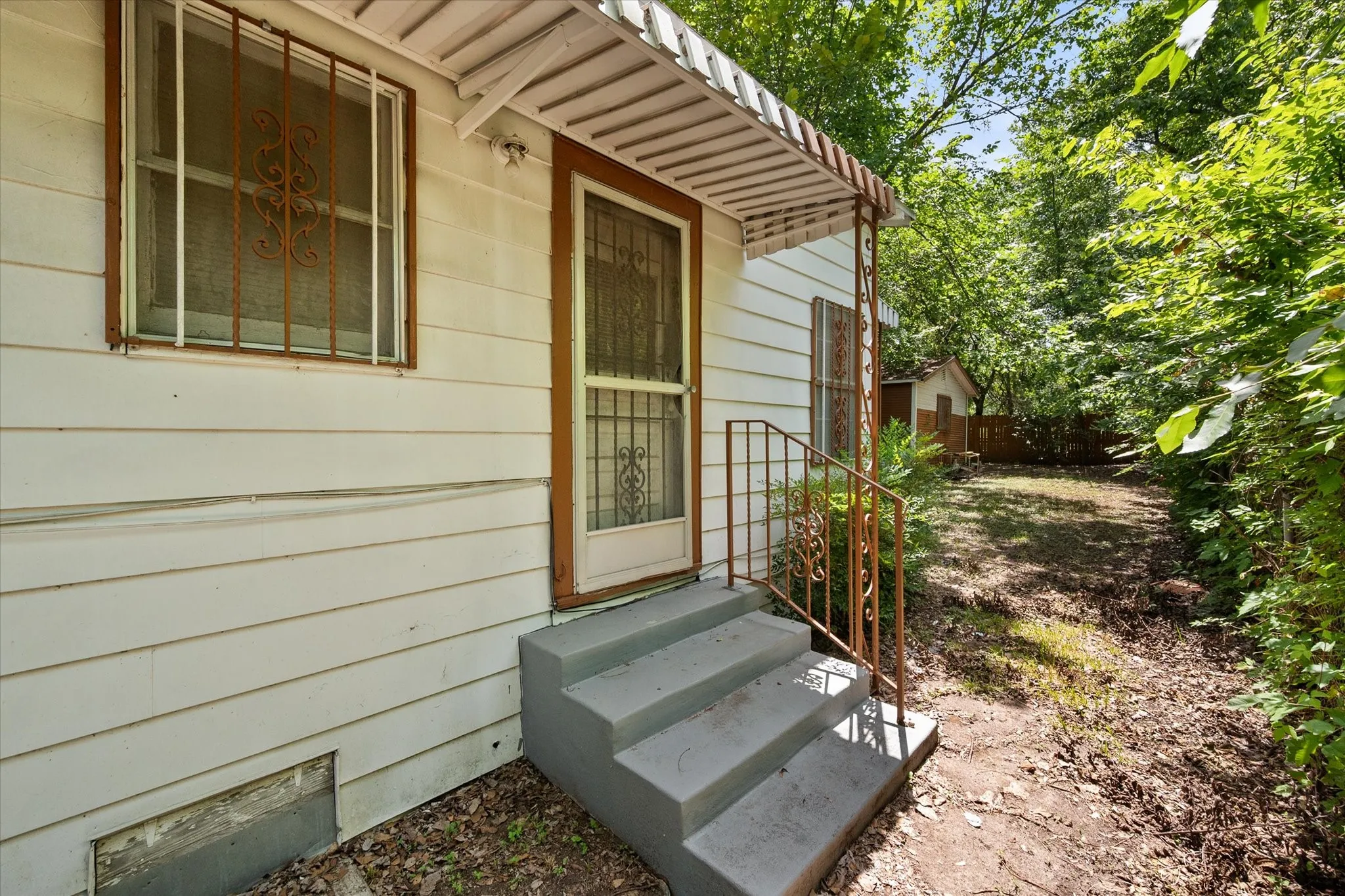 A covered side entry provides convenient access to the home and the tree-shaded yard.