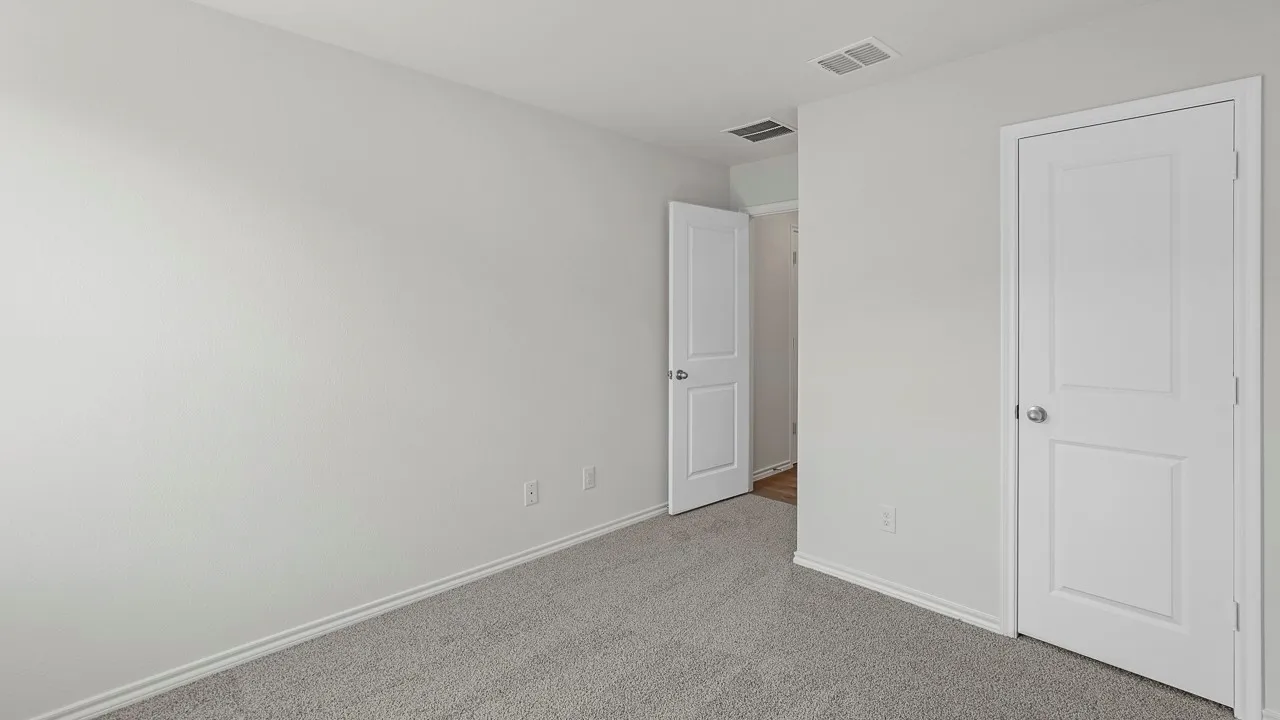 Neutral-toned room featuring grey carpet, white walls, and white trim