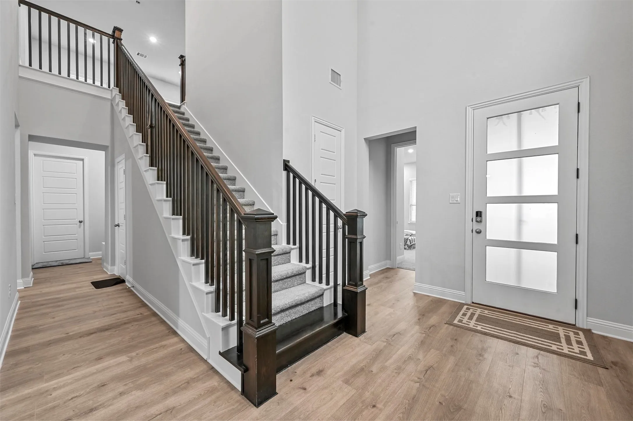 Entrance foyer featuring light wood flooring and a high​​‌​​​​‌​​‌‌​‌‌​​​‌‌​‌​‌​‌​​​‌​​ ceiling