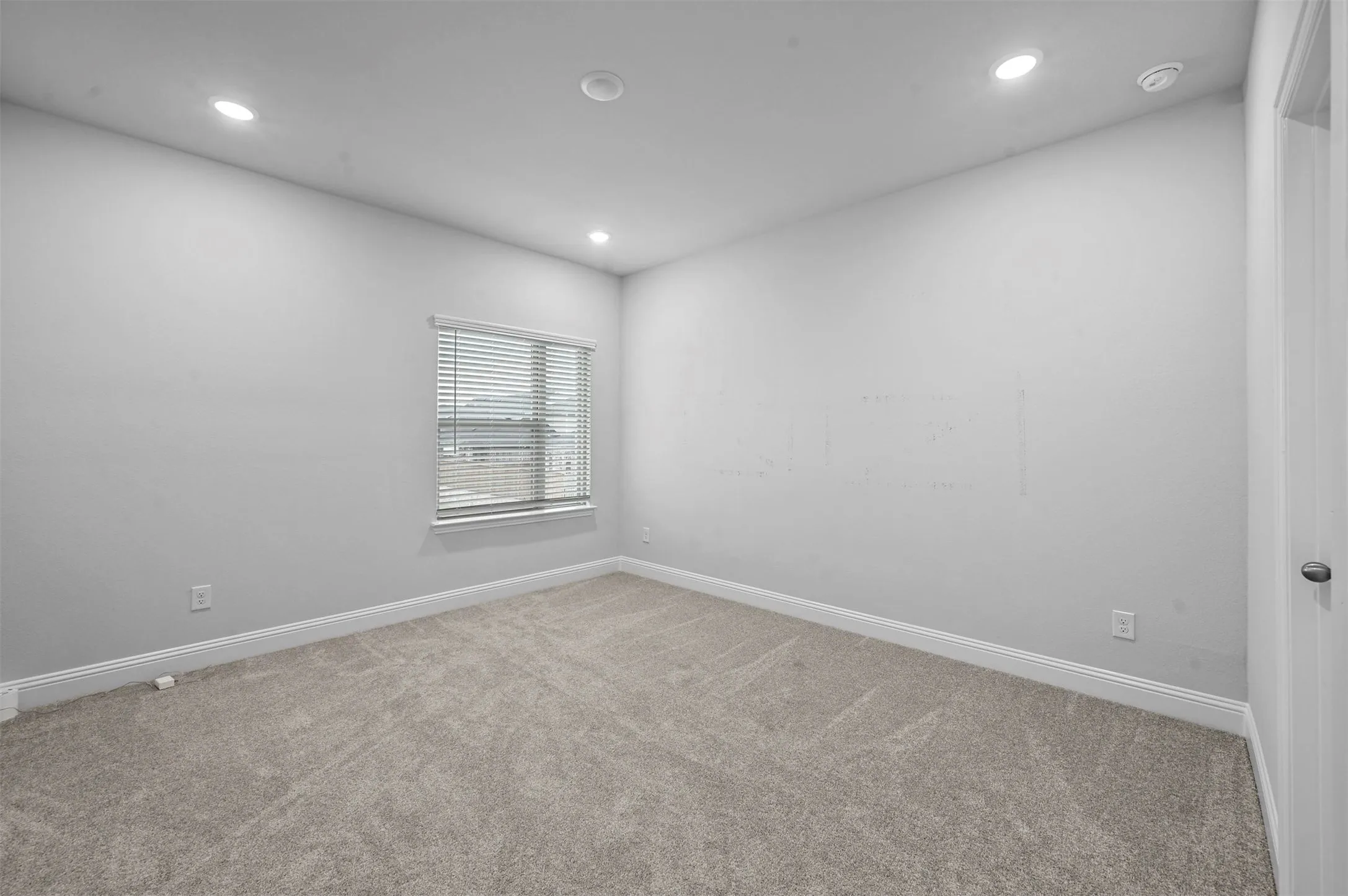 Spare room featuring light colored carpet and recessed lighting