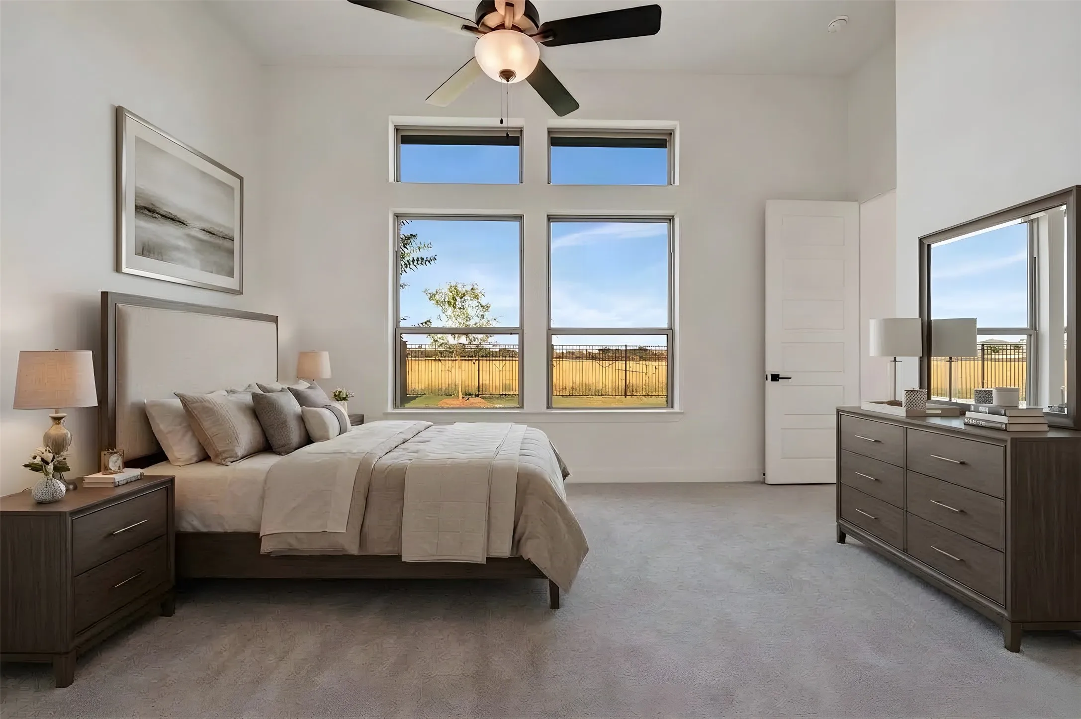 High ceilings with a ceiling fan, multiple windows, light-toned walls, and grey carpeting