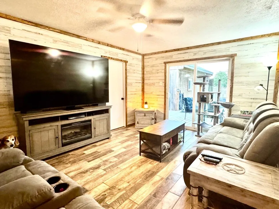 Living area featuring wood-finish flooring and horizontally paneled accent walls