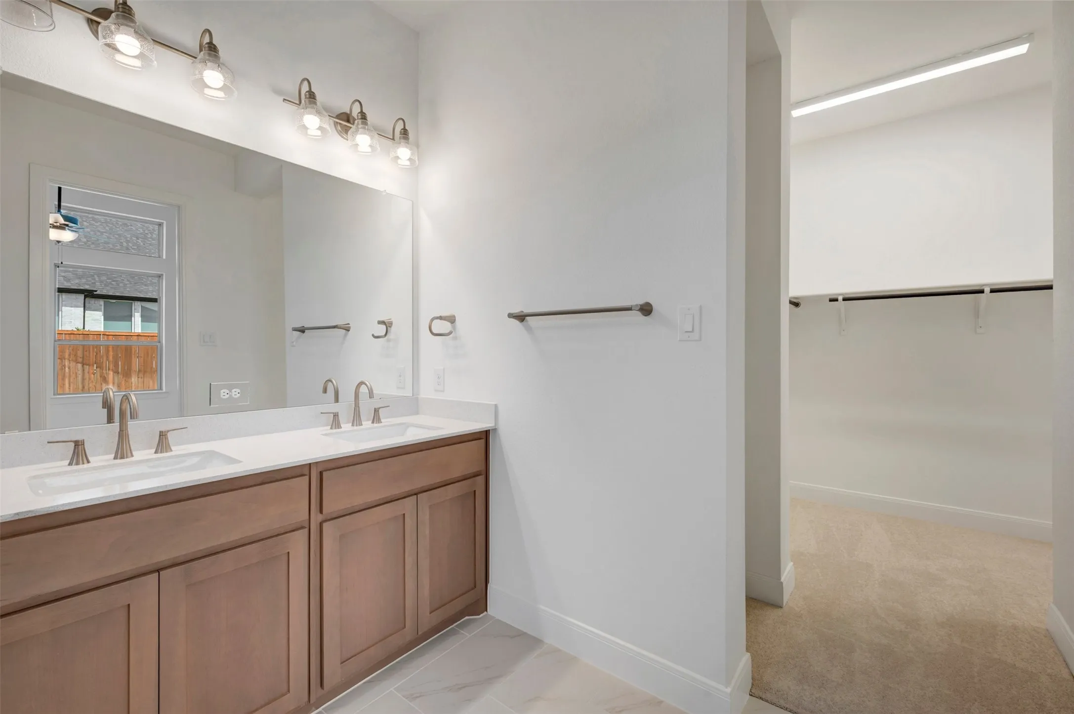 Dual vanity with wood-finish cabinetry and undermount sinks