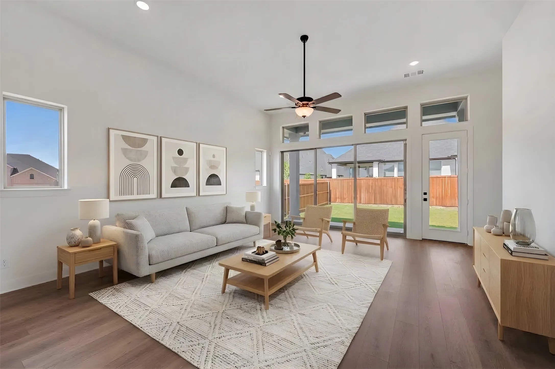Spacious living area featuring wood-finish flooring, vaulted ceilings, recessed lighting, and a ceiling fan