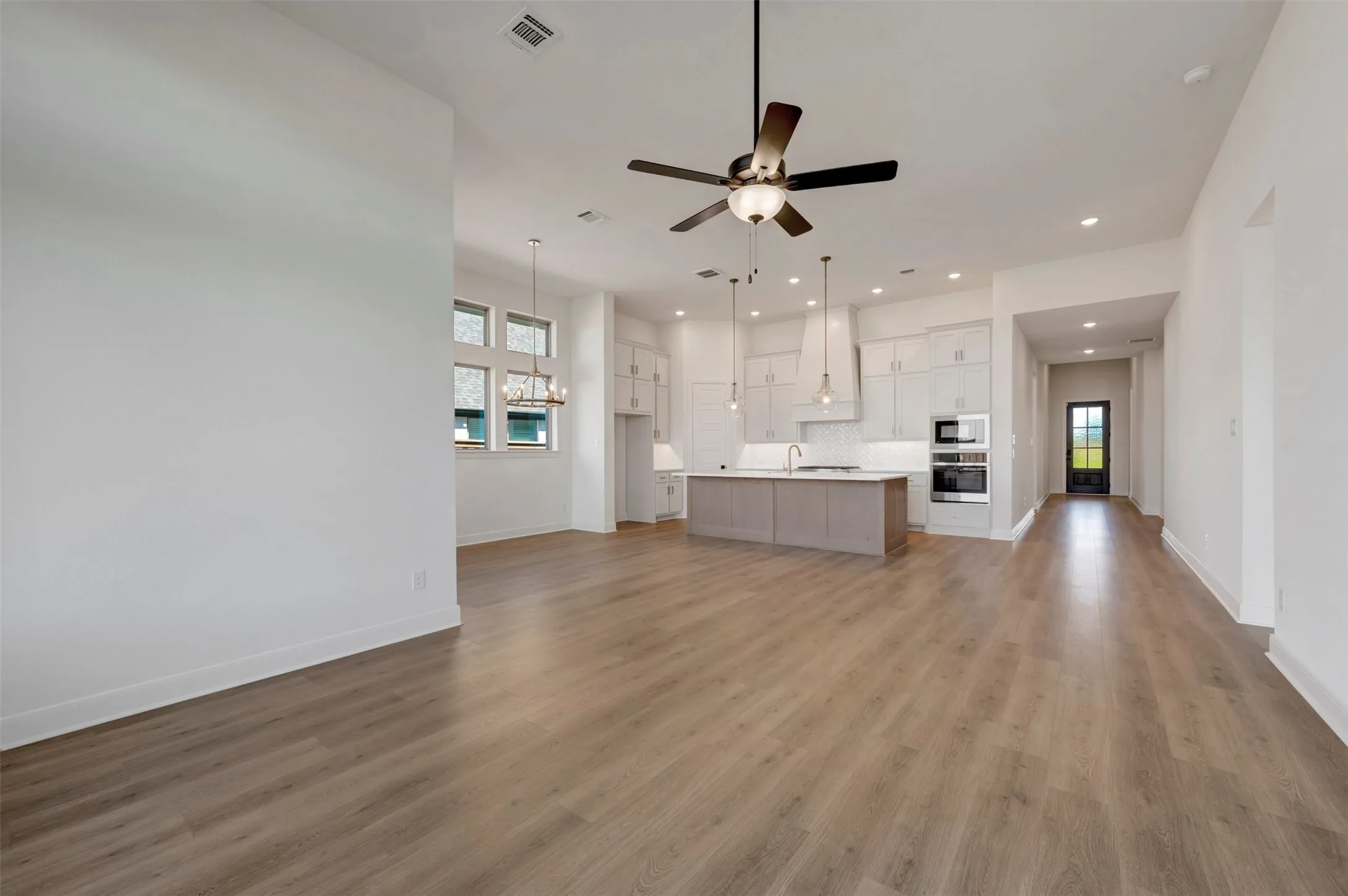 Open-concept living area featuring wood-finish flooring, recessed lighting, and a modern ceiling fan