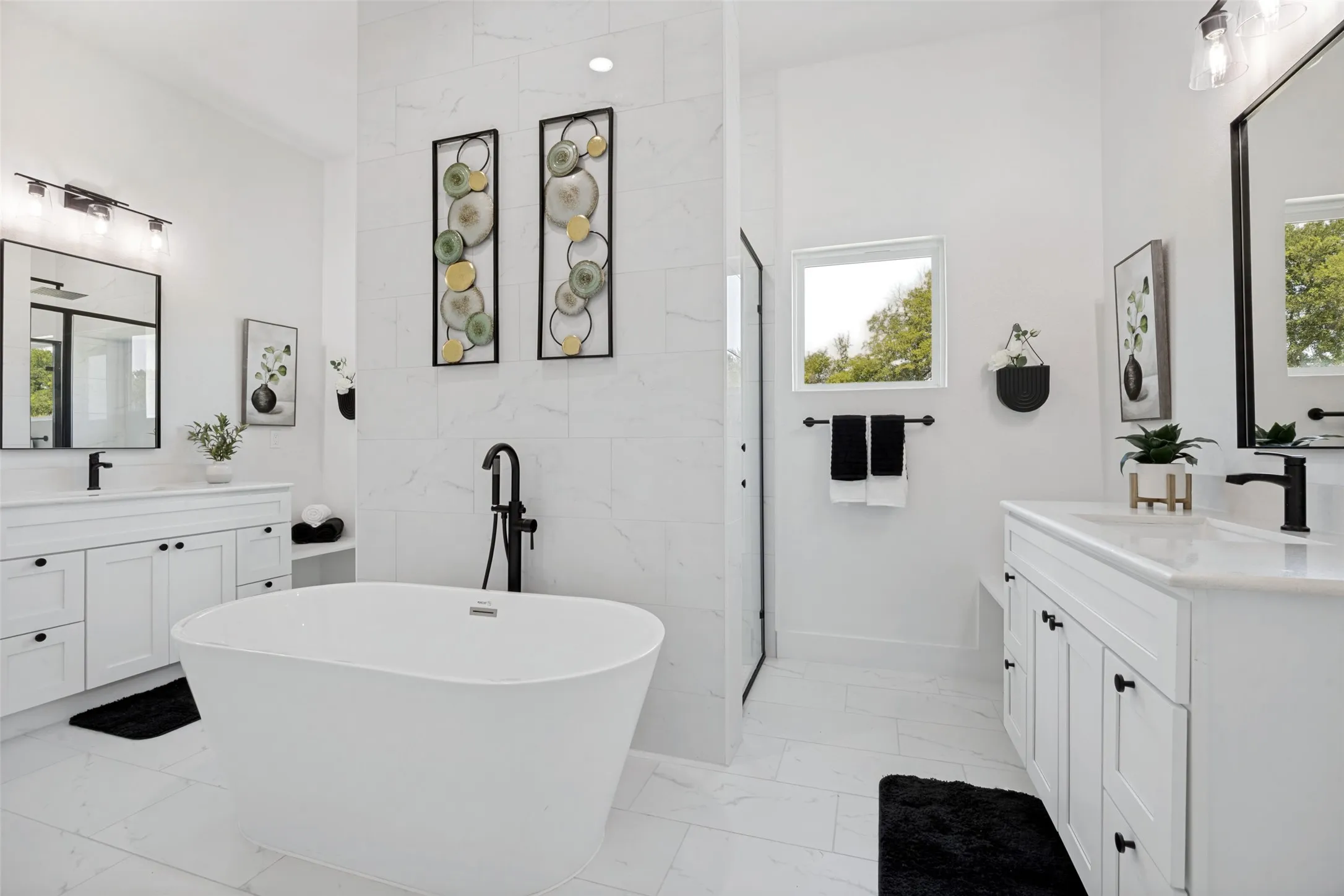 Freestanding soaking tub with a floor-mounted black faucet, set against white tile flooring and walls