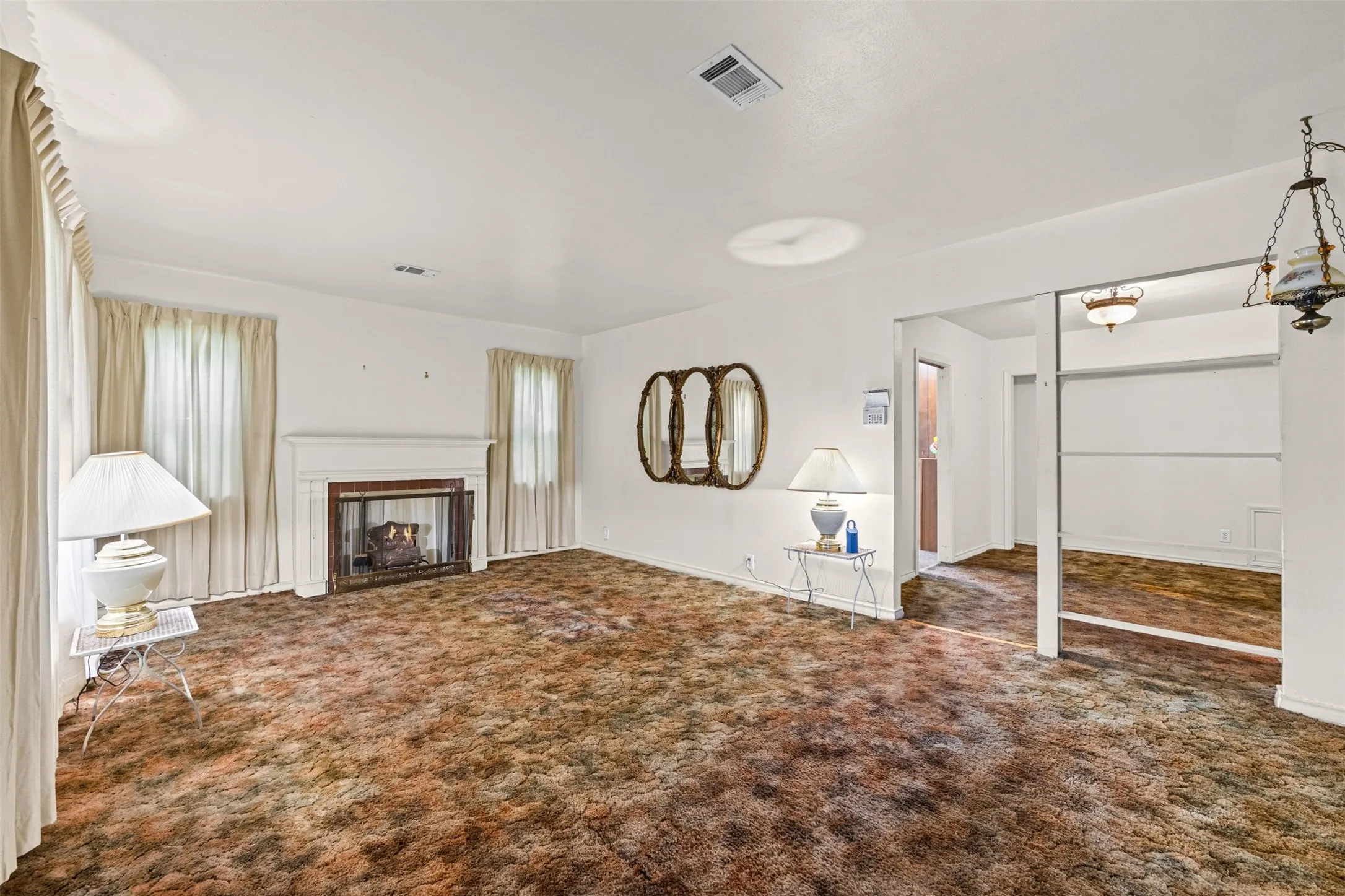 Living room has decorative fireplace with gas burning logs