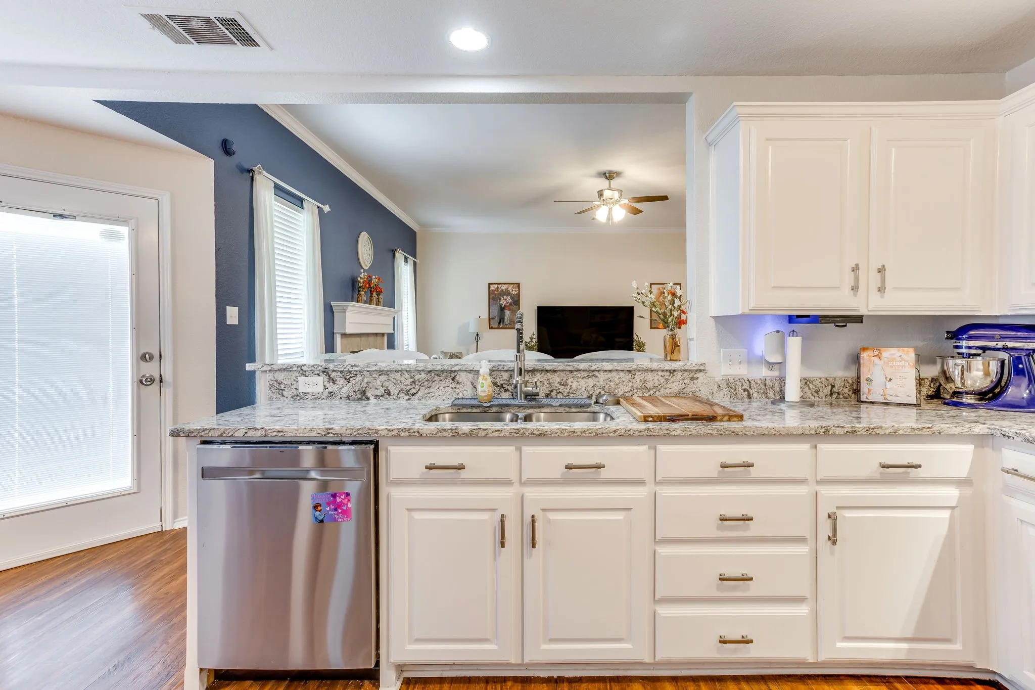 Kitchen featuring stainless steel dishwasher with brushed texture front panel, and a white exterior entry door featuring a single, full-light clear glass panel.