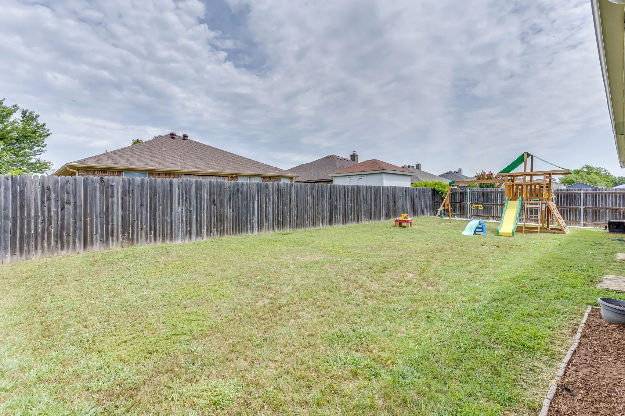 Backyard featuring yard boundary fully enclosed with a vertical wooden privacy perimeter fence.