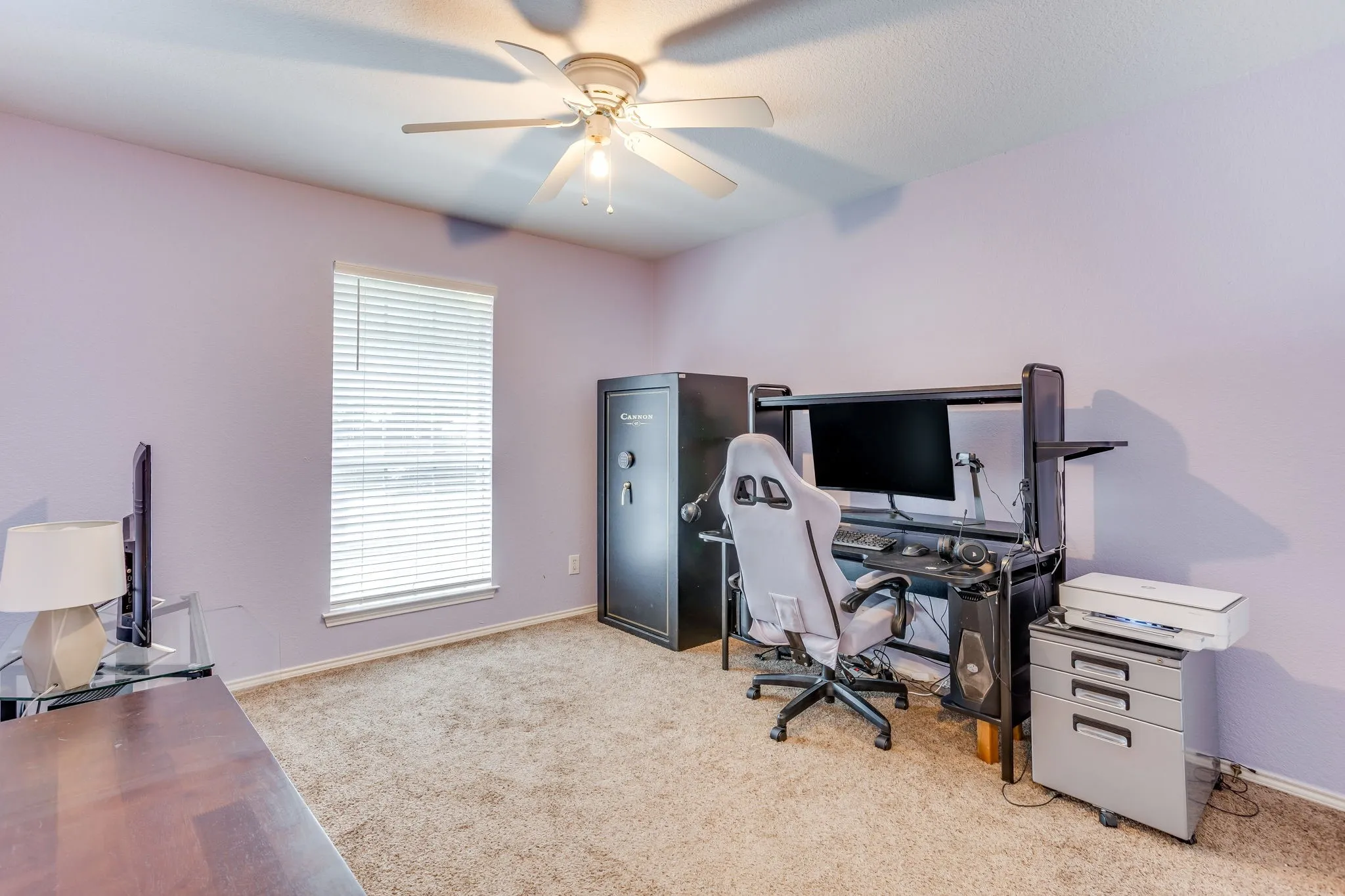 Office featuring a vertical window, wall to wall carpet, and overhead ceiling fan with integrated lighting.
