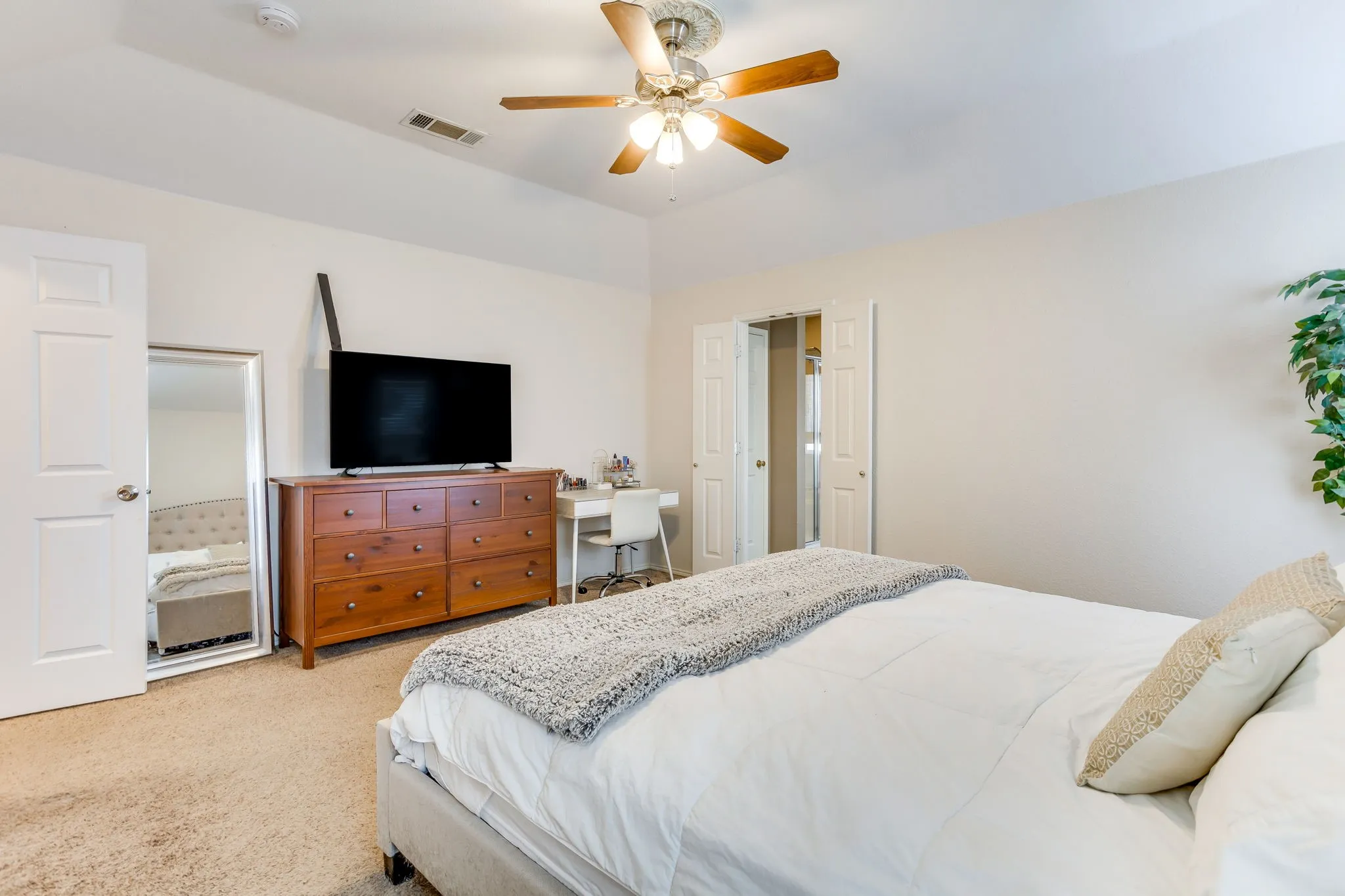 Primary bathroom featuring a centrally mounted five-blade ceiling fan and integrated light fixture with frosted glass shades.