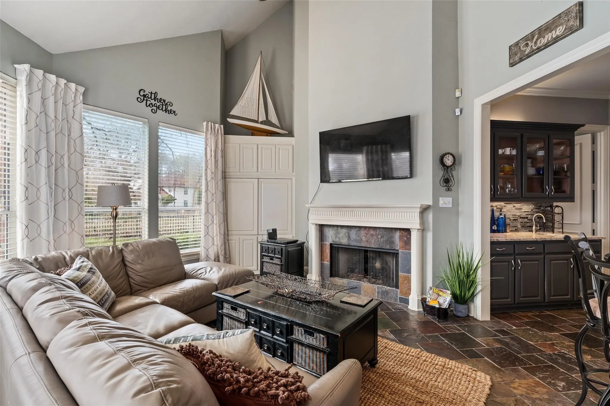 Living area featuring a floor-to-ceiling fireplace with a decorative mantel and stone surround
