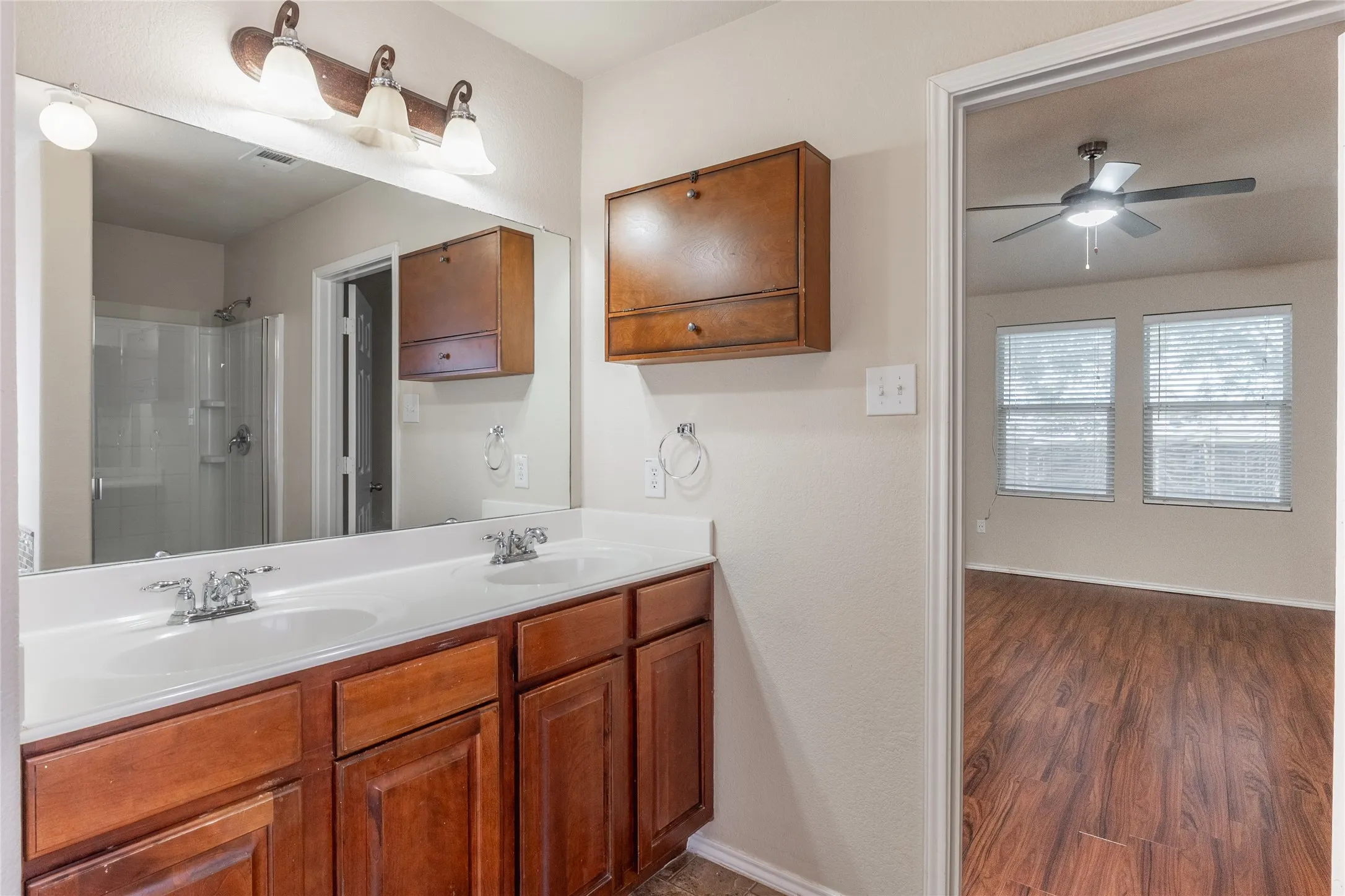 Dual vanity with white undermount sinks and wood-finish cabinetry