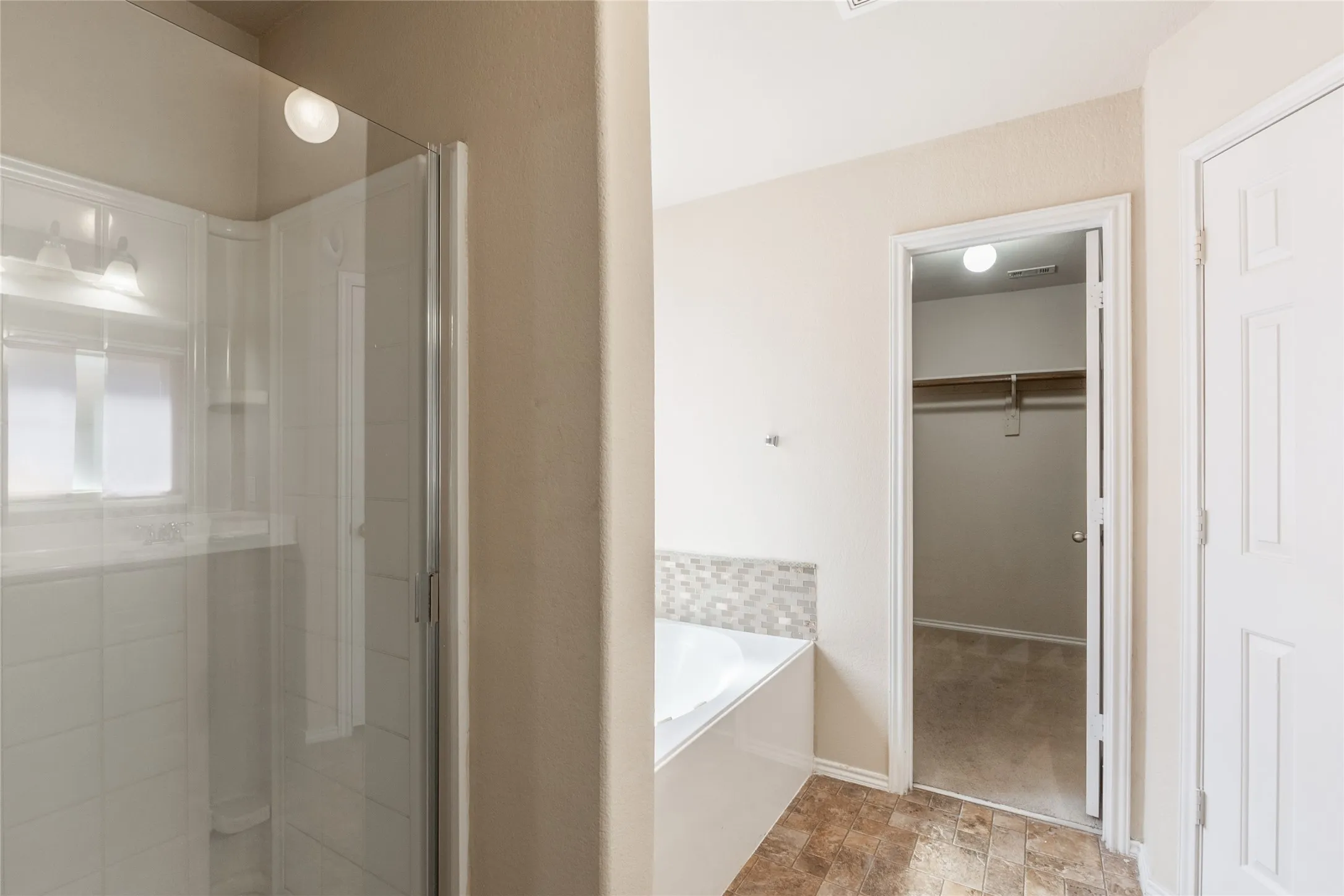 Bathroom featuring a glass-enclosed shower, a built-in bathtub with a mosaic tile surround, and wood-finish flooring