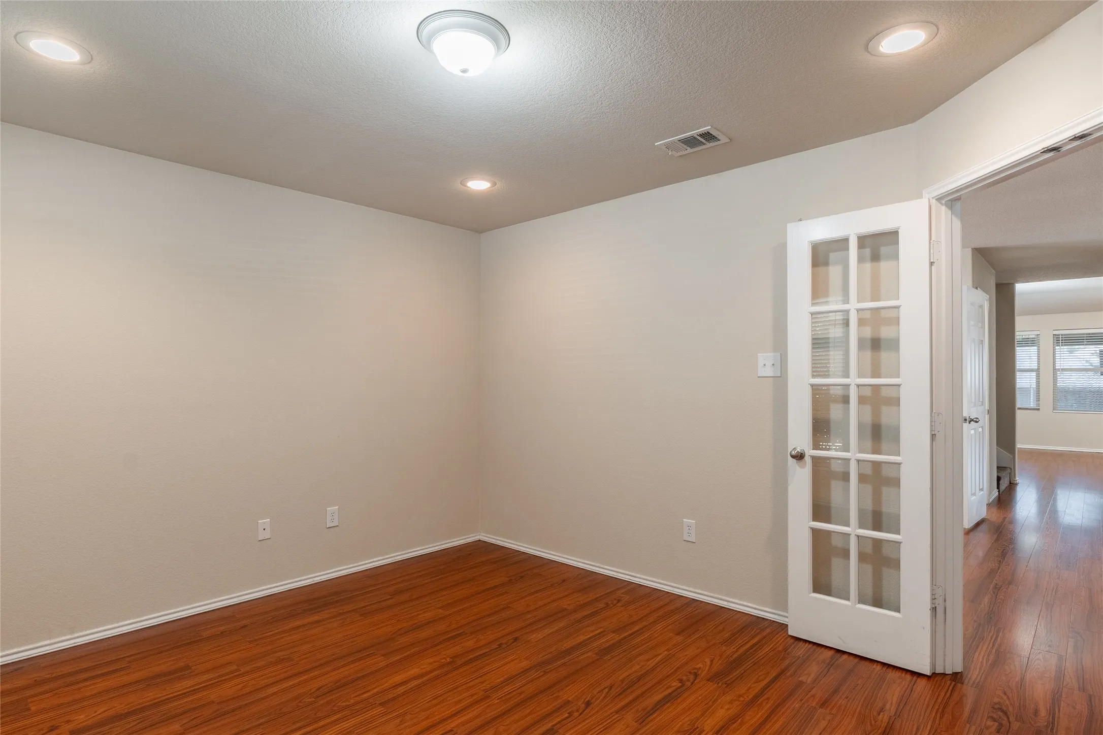 Versatile interior space featuring wood-finish flooring, neutral wall tones, and recessed lighting