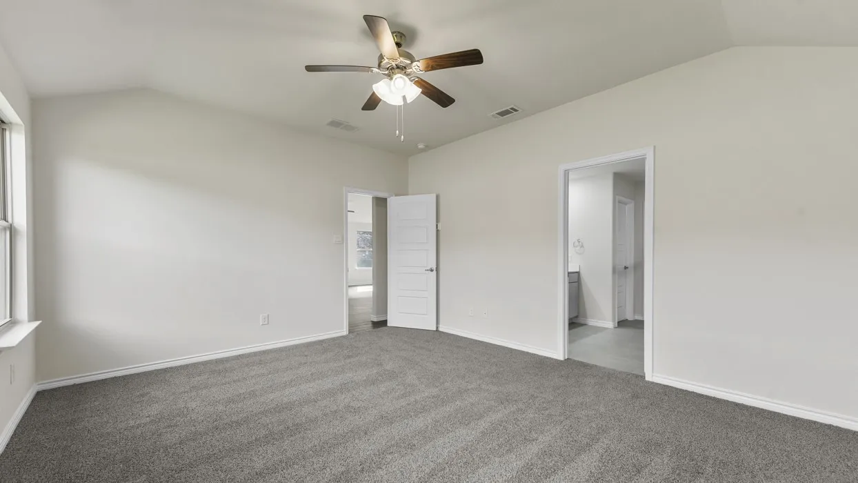 Carpeted room featuring a vaulted ceiling and a ceiling fan with integrated lighting
