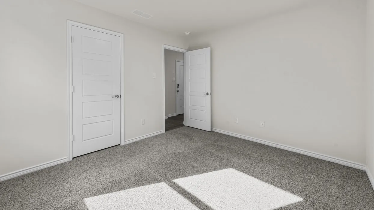 Neutral-toned room featuring light gray walls, dark gray carpet, white trim, and a white paneled door