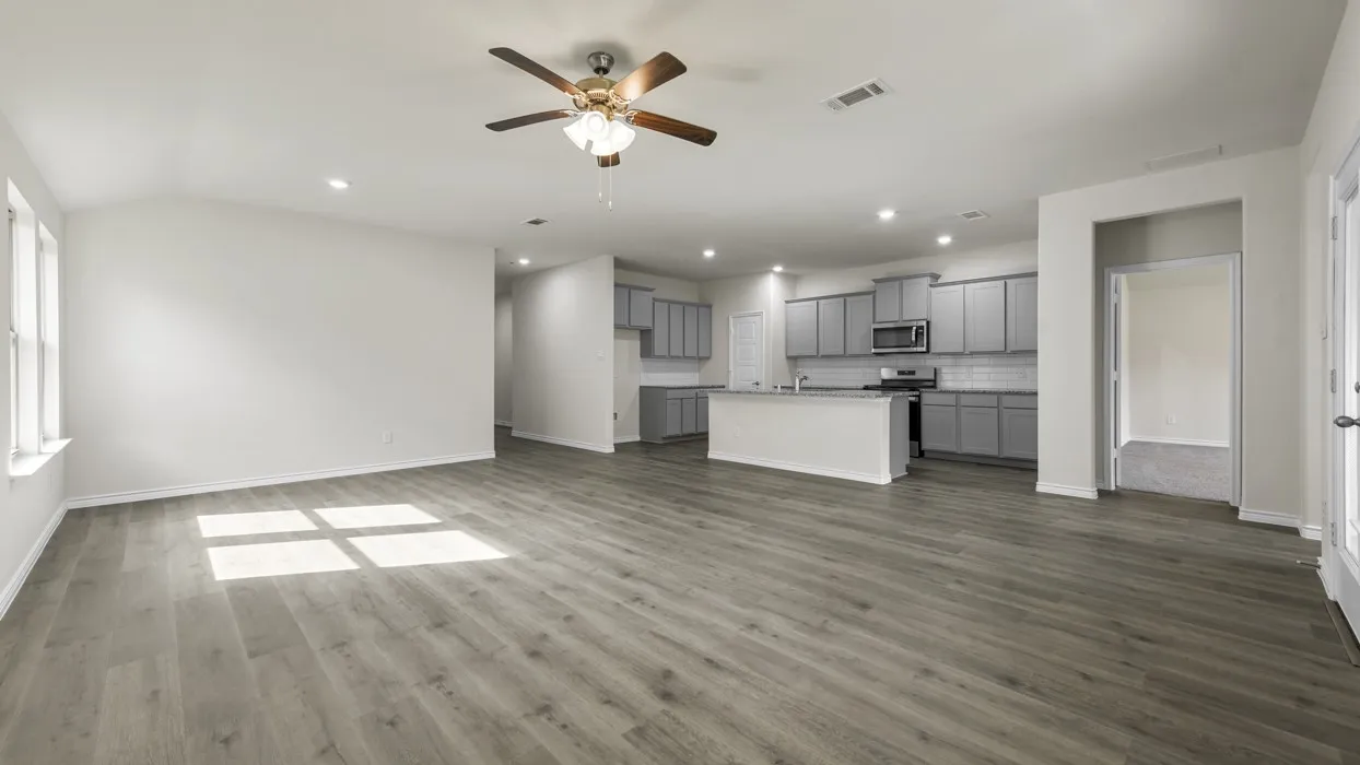 Expansive interior featuring wood-finish flooring, a ceiling fan, recessed lighting, and light gray cabinetry