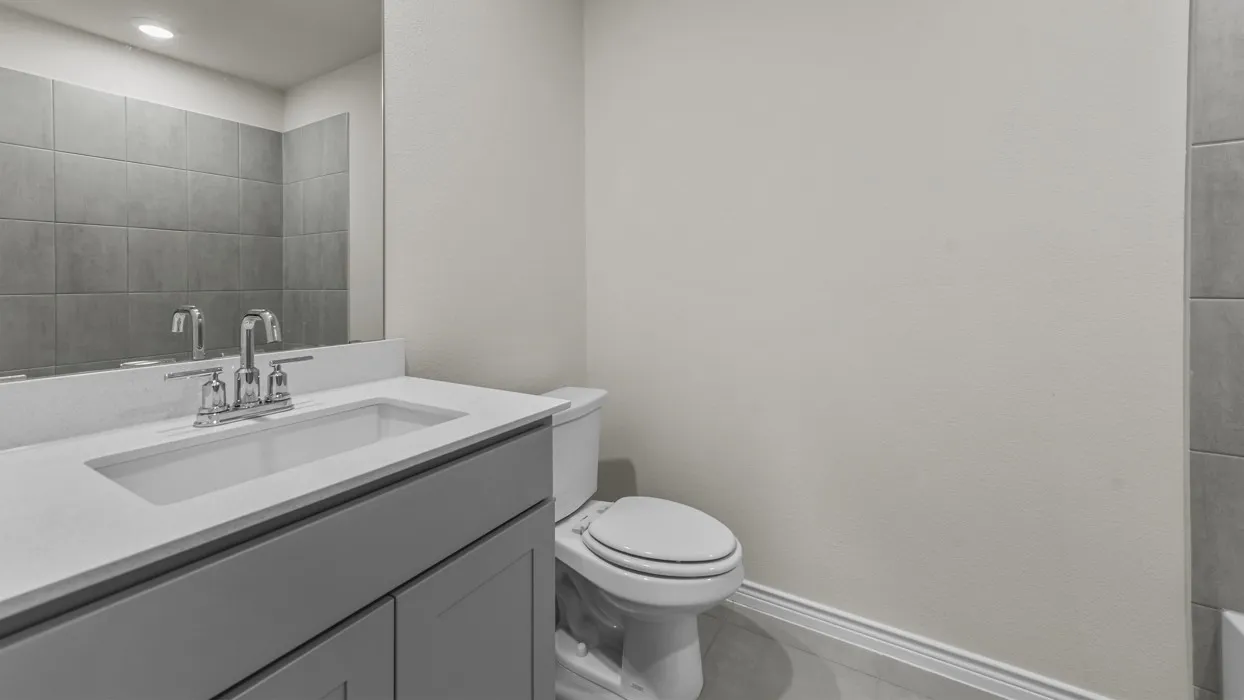 Bathroom featuring a single vanity with a white countertop, an undermount sink, and a chrome faucet