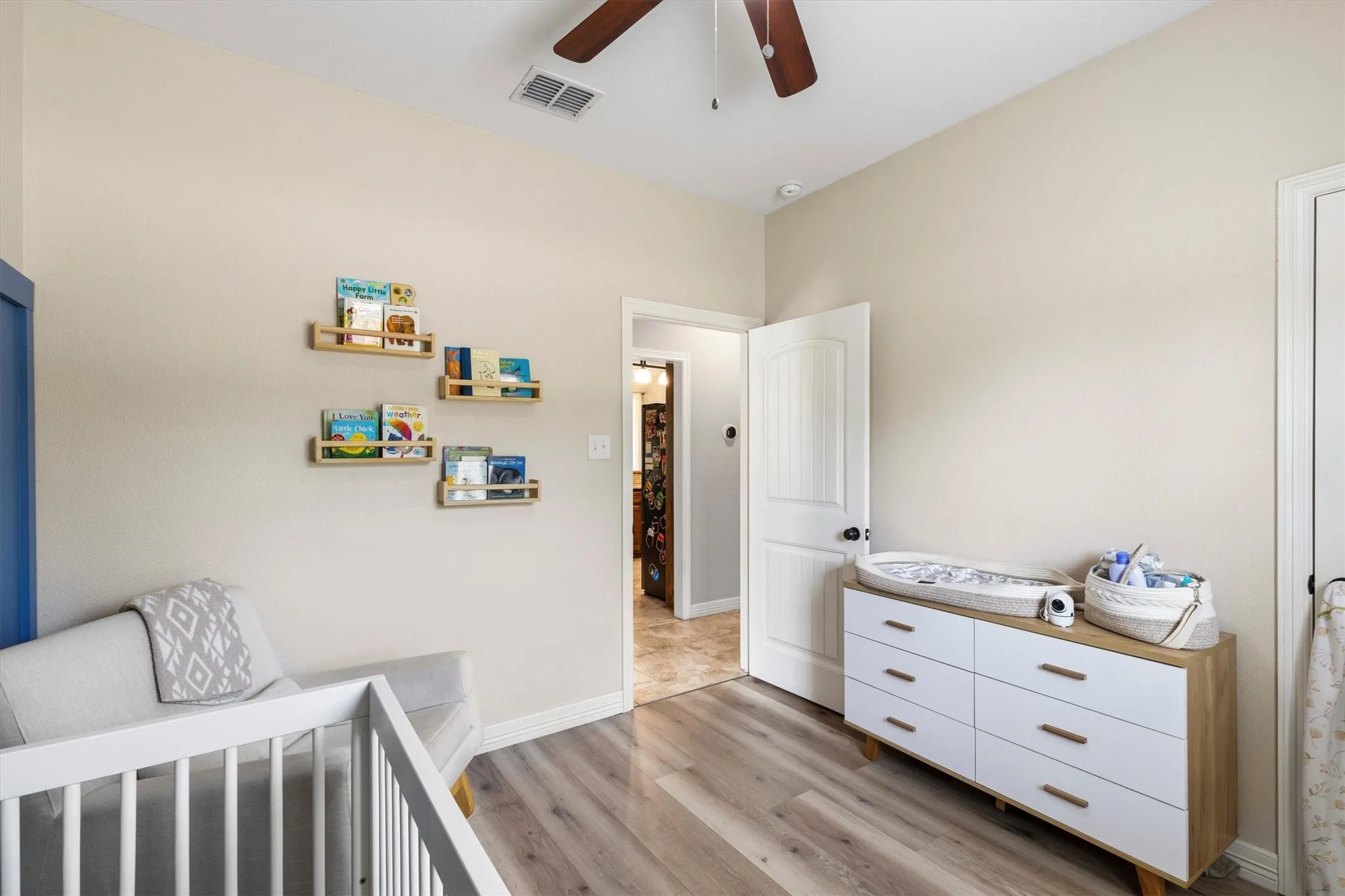 Interior room featuring light neutral wall tones and wood-finish flooring