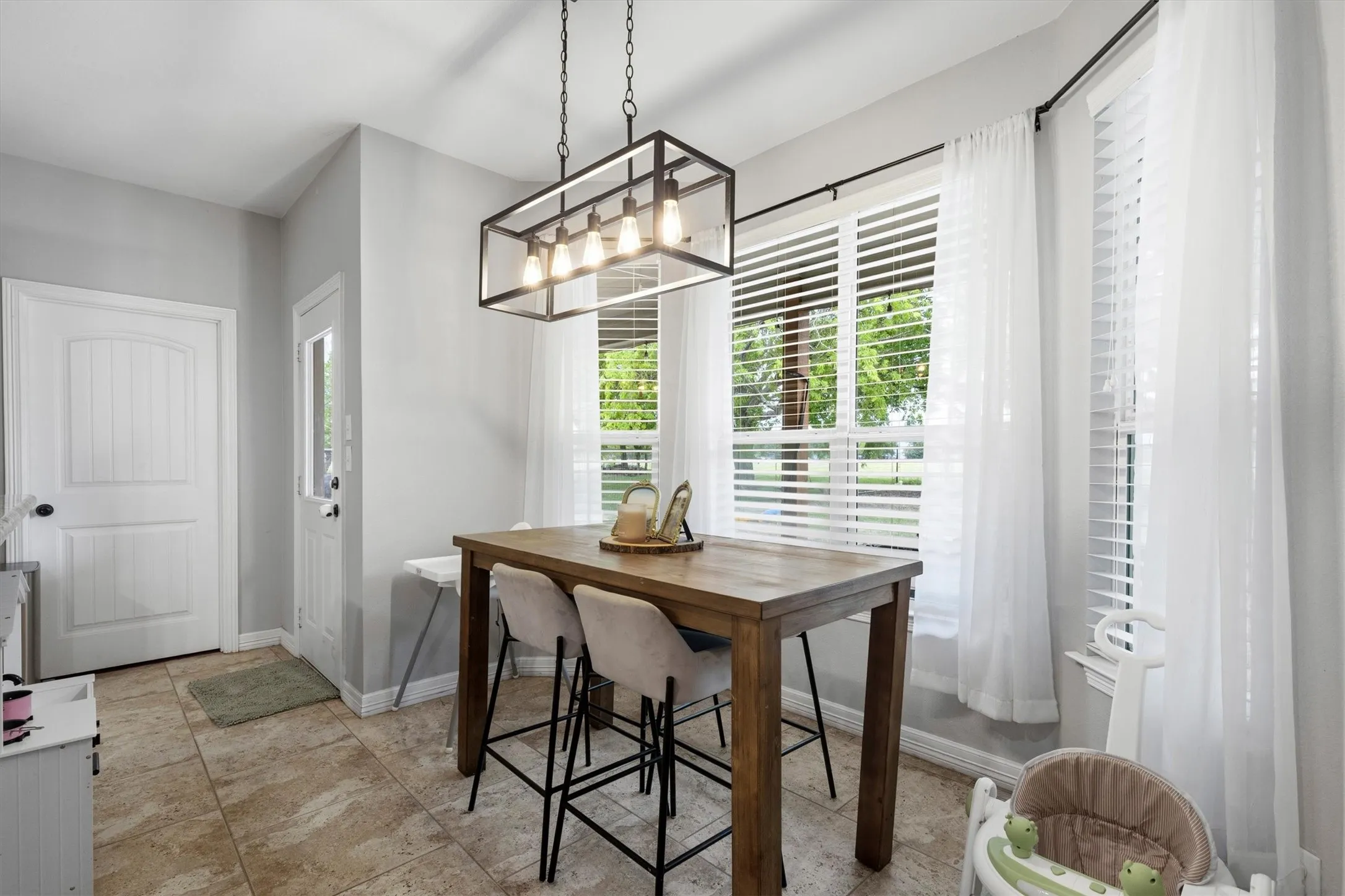 Dining area featuring neutral wall paint and large tile flooring