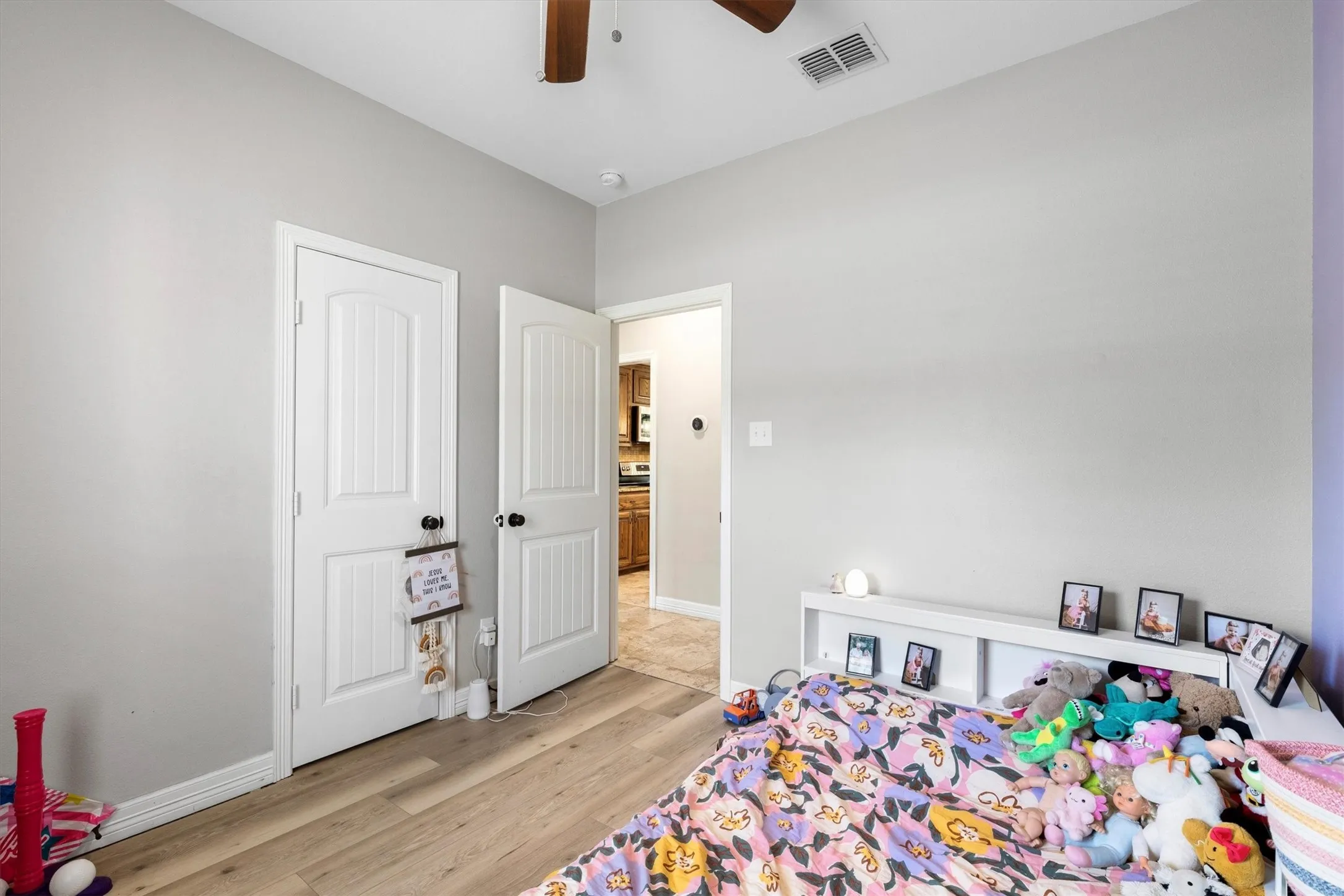 Interior room featuring wood-finish flooring, light gray wall paint, and white trim