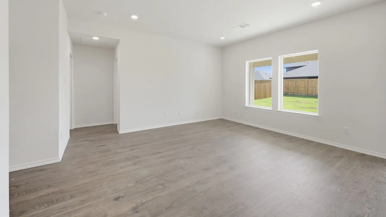 Spacious room with wood-finish flooring, recessed lighting, and bright white walls