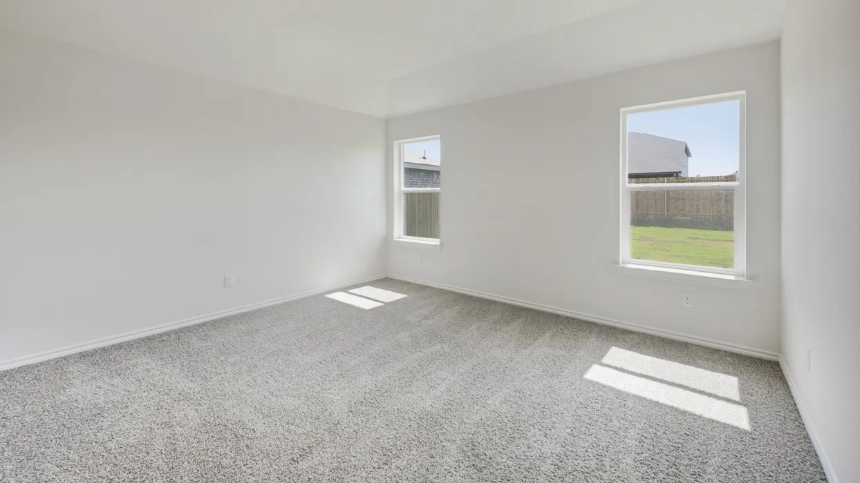 Spacious interior featuring neutral carpet flooring, white baseboards, and two windows