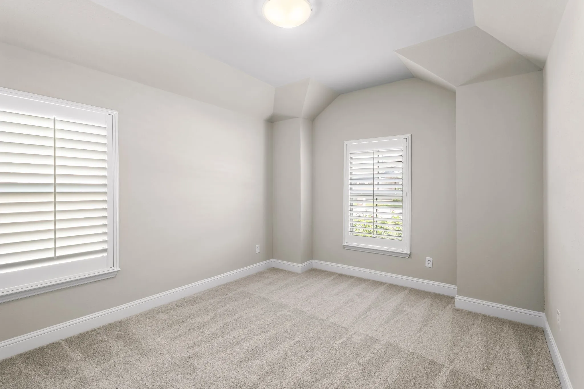 Carpeted room with neutral wall tones and white baseboards