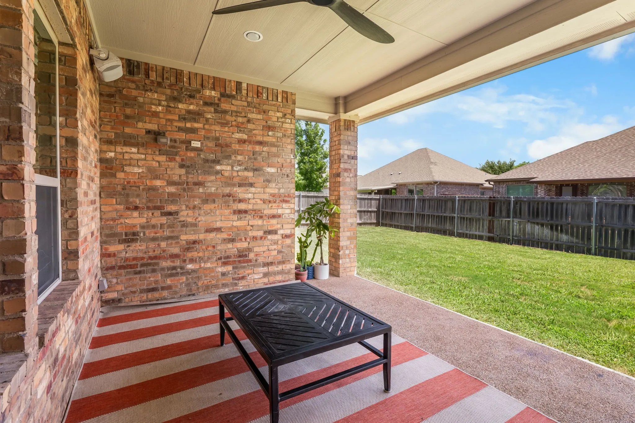 Covered patio featuring a ceiling fan, recessed lighting, brick exterior wall, and a concrete floor