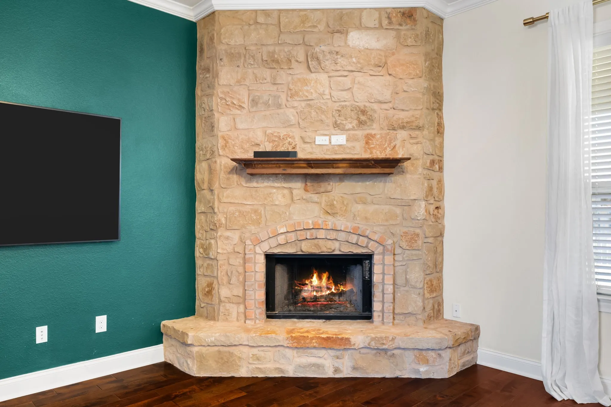 Stone fireplace with a brick firebox and a wood mantel