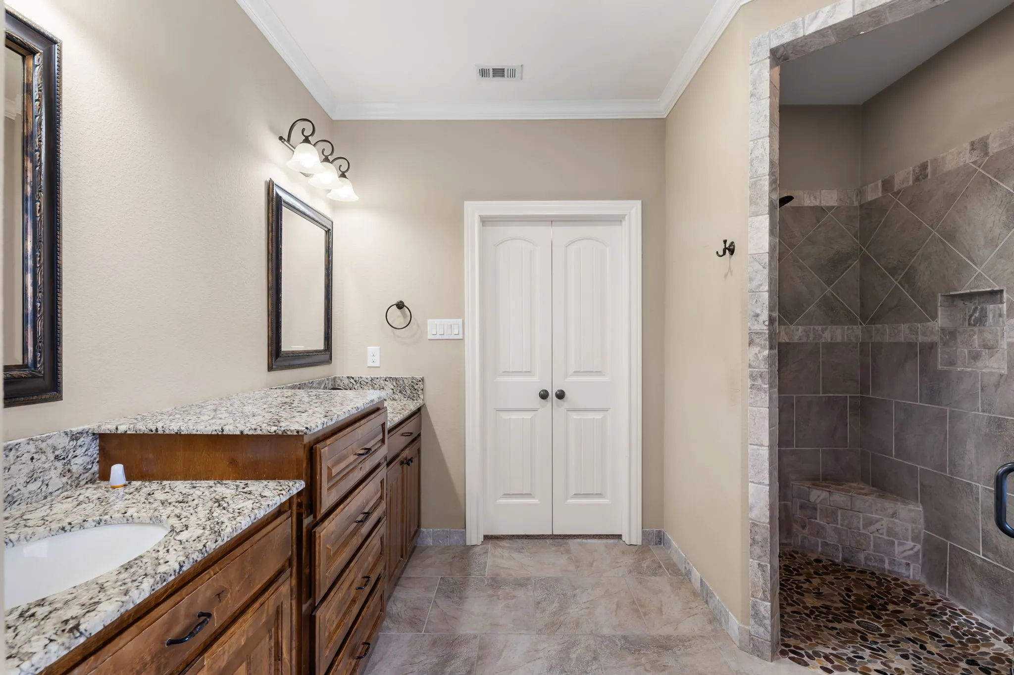 Dual wood-finish vanity with granite countertops and undermount sinks
