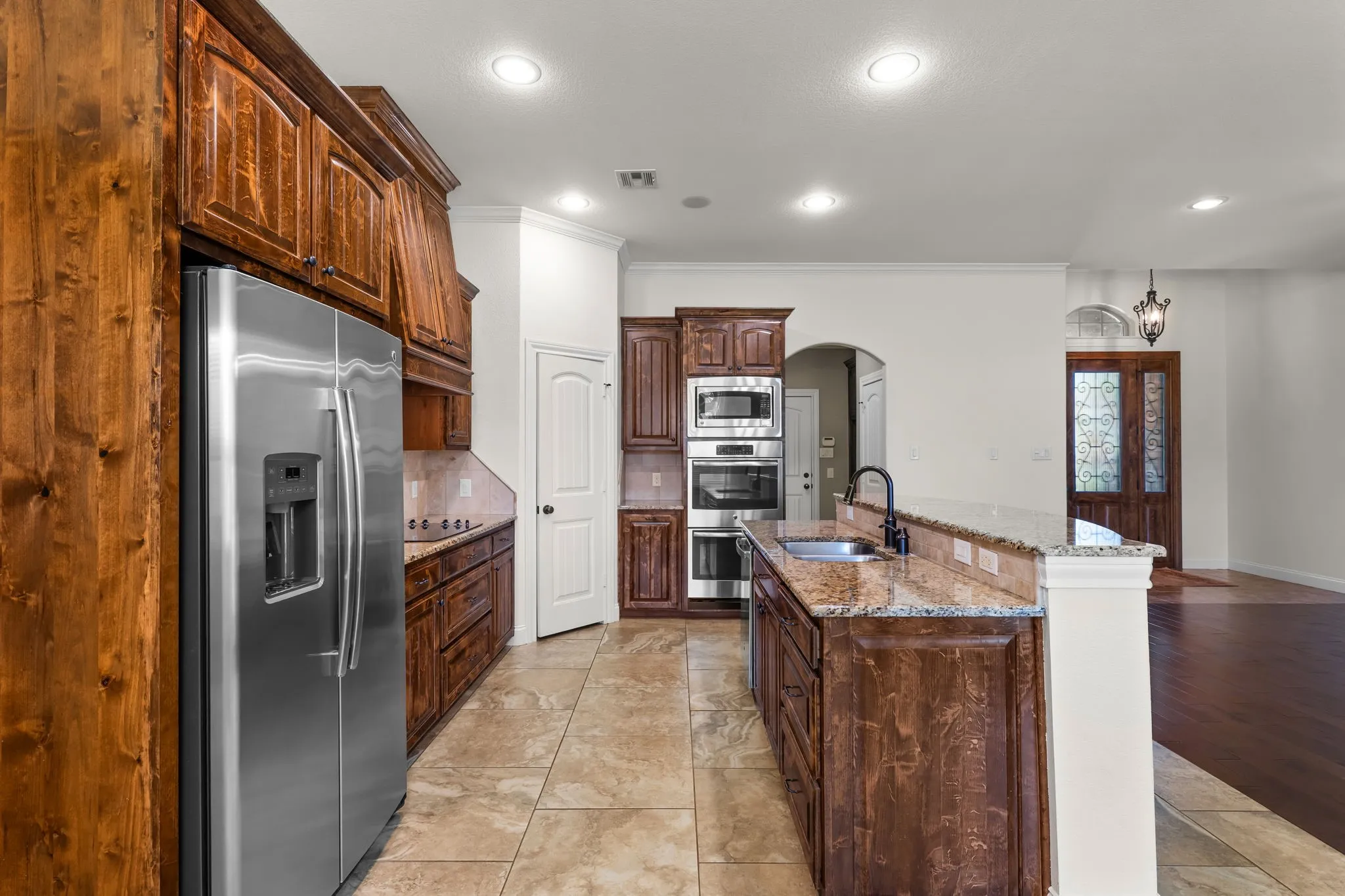 Kitchen featuring wood cabinetry, stainless steel appliances, a bar-height counter, and tile flooring