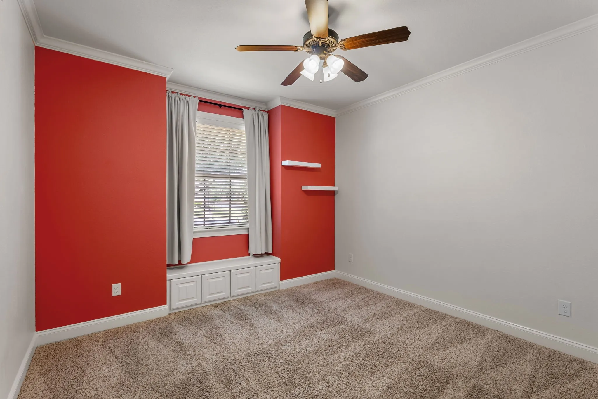 Room featuring a window with built-in storage bench, a ceiling fan, crown molding, and neutral-toned carpeting