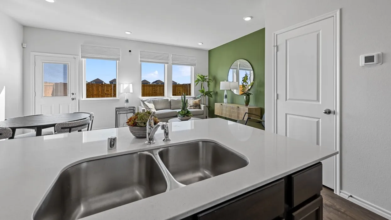 Kitchen island featuring a dual stainless steel sink, chrome faucet, and light-colored countertop