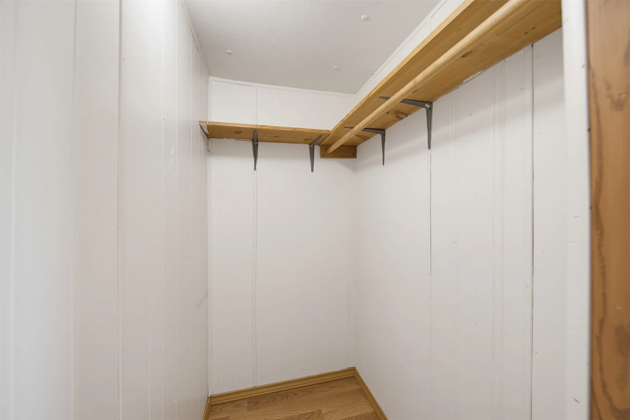Interior space featuring white vertical paneling and light wood-finish flooring